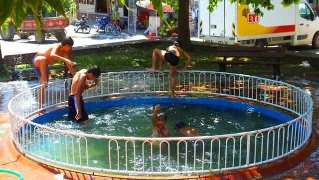 Bigadiç’te çocuklar süs havuzunda serinliyor