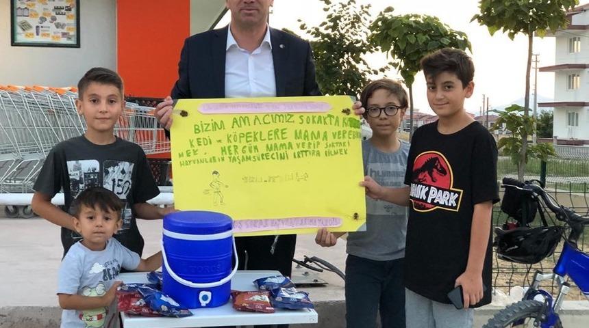 Limonata satarak sokak hayvanlarına bakıyor